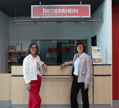 Foto: Annika Zingel; Die Geschäftsführerin von Niederrhein Tourismus, Martina Baumgärtner (l.) und die Leiterin der Wirtschaftsförderung Kreis Kleve, Brigitte Jansen, am Counter von NT am Flughafen Weeze. 