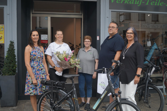 BU: Christina Kurschat (mit Blumenstrauß) ist stolze Besitzerin eines neues E-Bikes. Mit ihr freuen sich (v.l.): Ulrike Cronen (Stadt Nettetal), Steffi Charné und Arnoud van Herk (Van Herk Bikes) und Martina Baumgärtner (Niederrhein Tourismus). Foto: Niederrhein Tourismus
